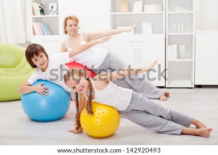 Kids exercising with their mother using large gymnastic balls