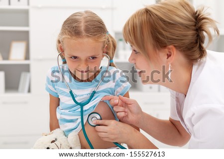 Little girl at the doctor for a checkup - listening to own heartbeat with stethoscope