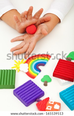 Child playing with colorful clay molding different shapes - closeup on hands