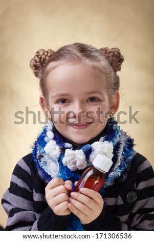 Little girl portrait with medical cough syrup in a bottle