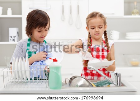 Kids washing the dishes in the kitchen together - helping out with the home chores