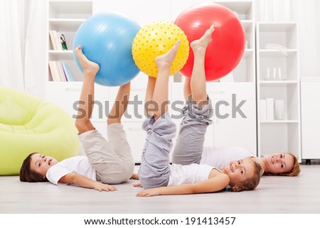 Happy and healthy family exercising at home using large gymnastic balls