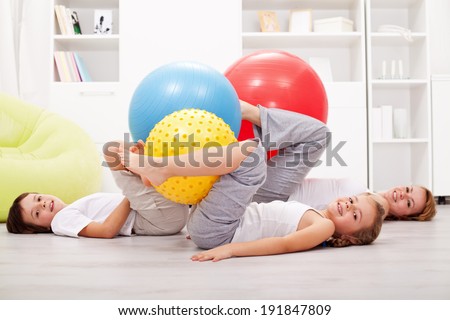 Family exercising with large gymnastic balls - laying on the floor at home
