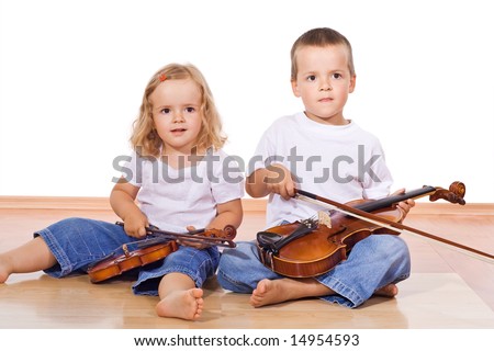 Little boy and girl with violins sitting on the floor - isolated