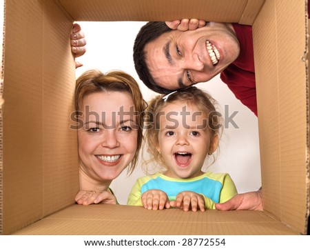 Happy family opening cardboard box - moving concept