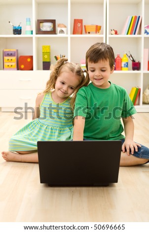 Kids with laptop, sitting on the floor playing