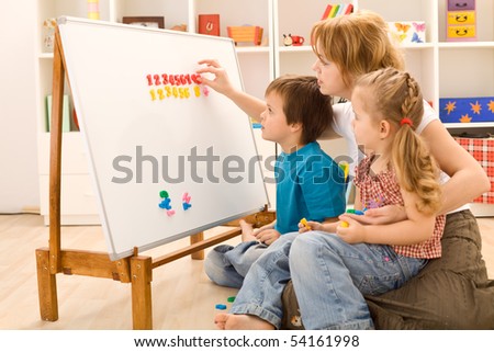 Kids learning the numbers with their mother and  a magnetic board