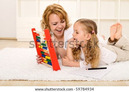 Little girl doing math exercises with her mother at home