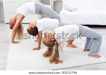 Woman and kids doing bridge stretch gymnastic exercises at home