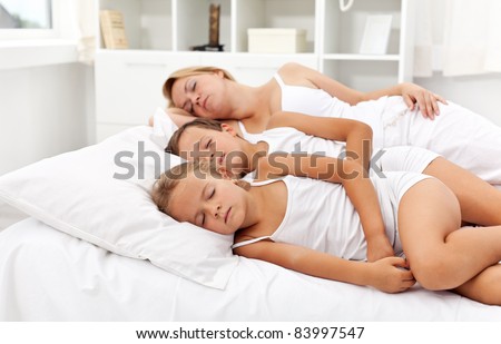 Nice summer siesta - woman and kids laying in bed having a nap