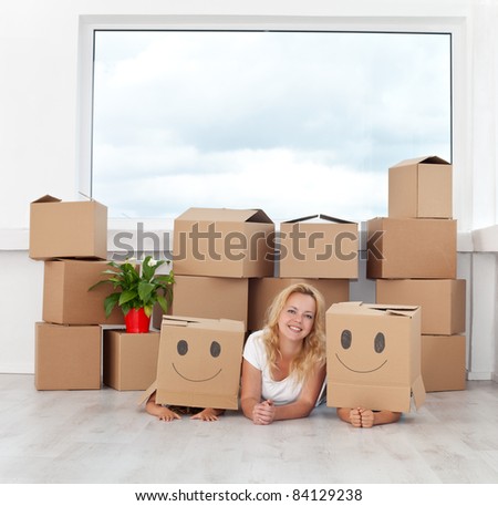 Happy people having fun in a new home with cardboard boxes and a plant