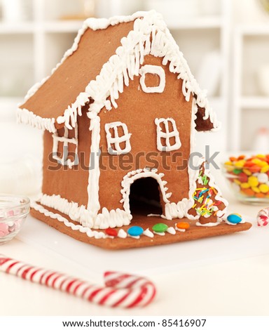 Christmas time in the kitchen with gingerbread house and candy stick