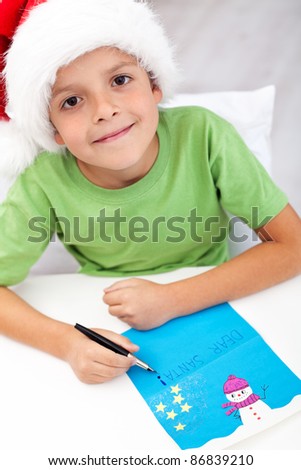Happy kid writing handmade decorated letter to santa