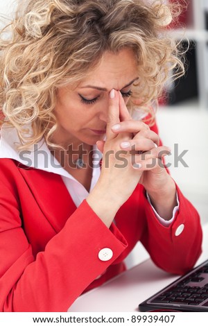 Taking a moment in the office - woman with headache having deep thoughts