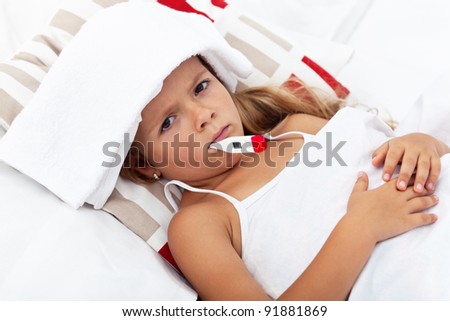 Sick little girl with thermometer and cold pack laying in bed