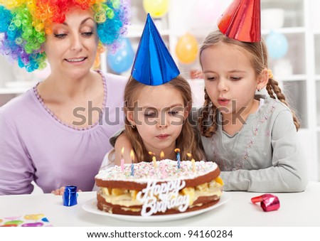 Birthday girl making a wish and blowing out candles on a cake
