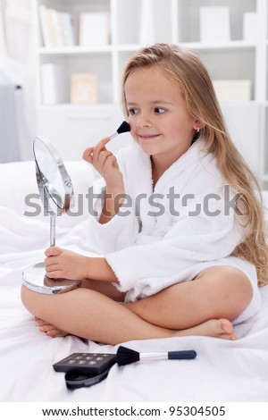 I am beautiful - little girl with makeup playing on the bed