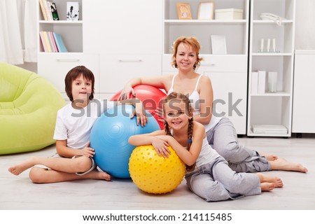 Woman and kids ready for gymnastic - sitting on the floor with large exercise balls