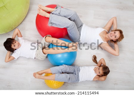 Abdominal workout - woman and kids doing gymnastic exercises, top view