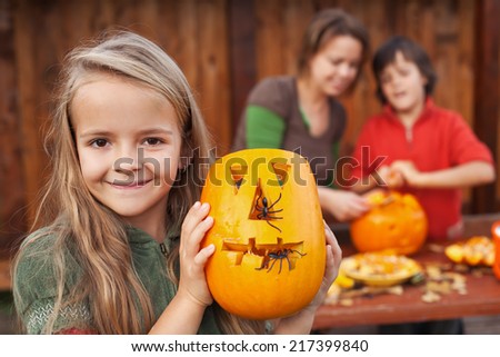 Little girl showing her freshly carved Halloween jack-o-lantern