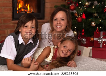 Happy Christmas family portrait - laying by the fire in front of xmas tree