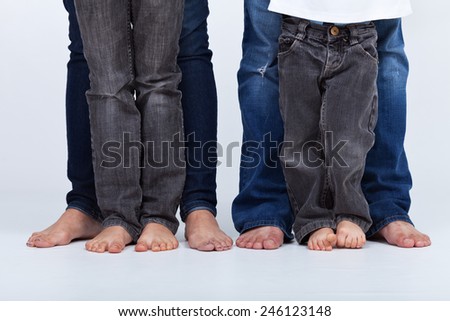 Family legs in jeans portrait - barefoot on white background