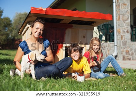 Family preparing the doghouse for the new family member - a labrador puppy