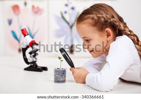 Young student studies small plant in elementary science class