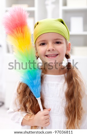 Little girl with dusting brush ready to clean the room - closeup