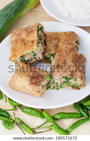 Indonesian Food Martabak Asin and birds eye chili in white plate (vertical version)