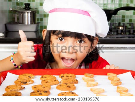 Asian Little Girl posing taste good cookie in the kitchen