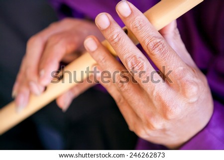 Man playing bamboo flute musical instrument suling