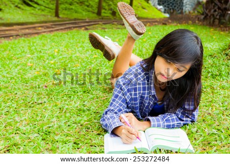 Asian girl seriously studying in the park