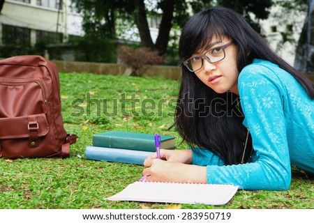 College student writing home work outdoor in university