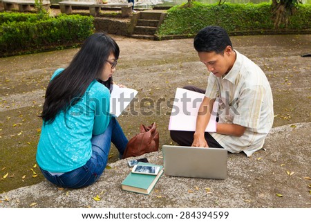 Student studying in university with books and computer