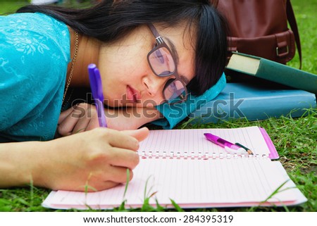 College student doing home work outdoor in university