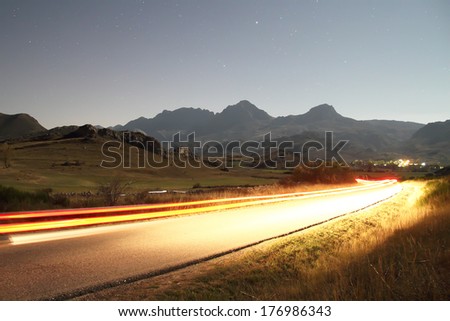 Car lights through a road in the night in Babia, Leon, Spain.