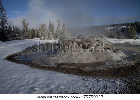 Yellowstone National Park in Winter, Wyoming USA - geyser and geothermal mineral pools with snow around the Firehole River.