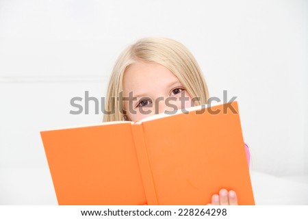Cute little girl is reading book