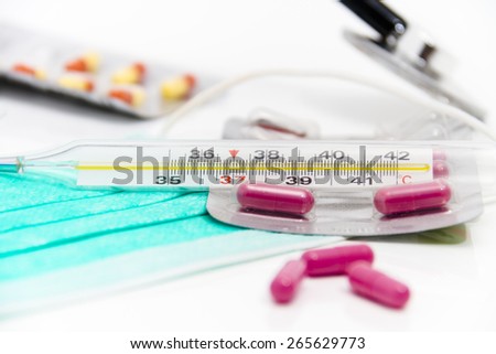 Set for flu treatment -  pills, thermometer, nasal sprays, protective surgical mask, stethoscope, syringe...