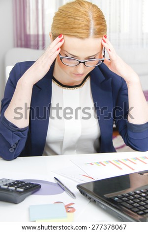 Business woman analyzing investment charts with calculator and laptop