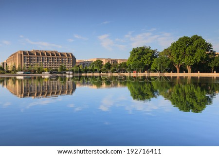 Washington, DC office building mirrored in the water of the US Capitol Reflecting pool.