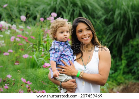 Mother holds child with garden blurred in background on a farm in northern Virginia.