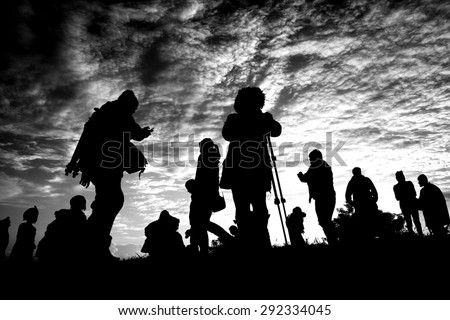 People walking on the hill with clouds. Silhouettes.Blurry focus and used black and white tool for dark tone.
