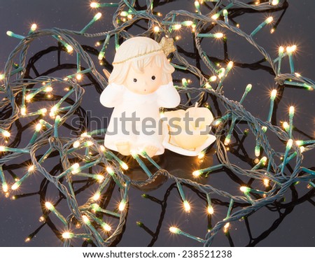 Candle with angel on christmas lights