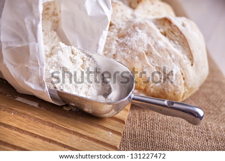 Image of a flour being scooped out and a whole loaf of bread.