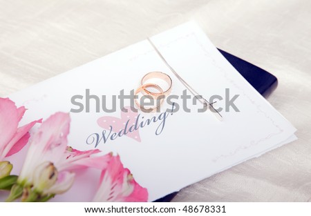 stock photo Pair of wedding rings on a bible with cross and flower