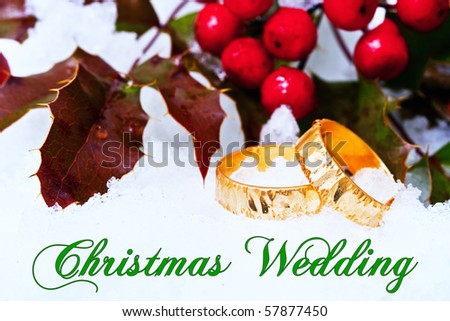 A conceptual image of a wedding proposal at Christmas time with a pair of gold rings resting on some freshly fallen snow.