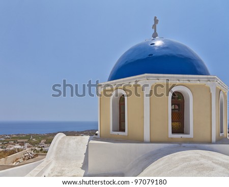 An image of a typical blue domed church in the Fira on the greek island of santorini.