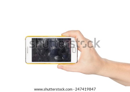 Hand holding white smartphone with fingerprint dirty screen